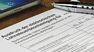 Kugelschreiber liegt auf einem Ausdruck der elektronischen Lohnsteuerbescheinigung.