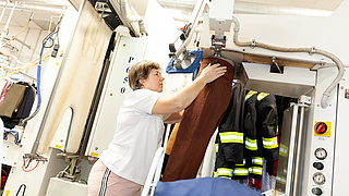 Textilreinigerin bearbeitet eine Hose