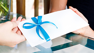 Receptionist woman gives certificate to visit of spa salon.