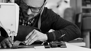 Mann arbeitet an einer Nähmaschine