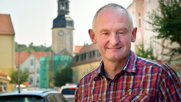 Uhrmacher Carsten Handrick vor einem Kirchturm in Spremberg.