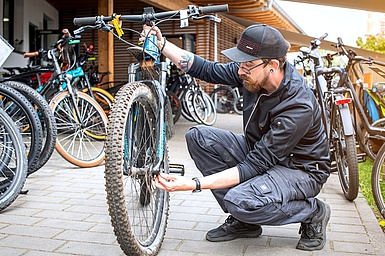 Ein Mitarbeiter des Zweiradshops Niederhofer stellt den Lenker am Fahrrad ein