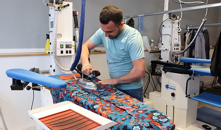 In der Bügelstation werden die Textilien finalisiert.