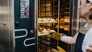 Bäckerin öffnet Ofen