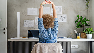 Frau dehnt sich vor dem Laptop