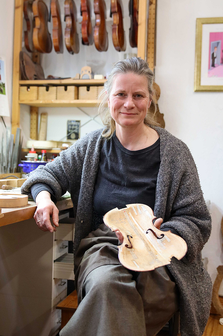 Geigenbauerin Constanze Bruns hält eine Geigendecke in der Hand.