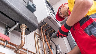 Handwerker bei der Kontrollemessung an einer Heizungsanlage.