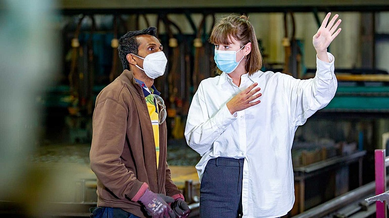 Die kaufmännische Leiterin Johanna Börgel ist im Gespräch mit einem Mitarbeiter in der Werkstatt.