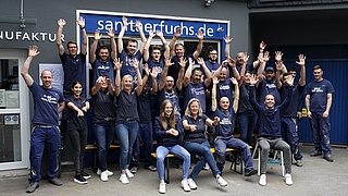 Sebastian Fuchs vor seinem Betrieb mit seinen Angestellten und Auszubildenden.