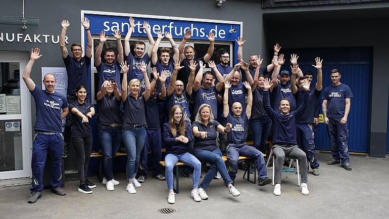 Sebastian Fuchs vor seinem Betrieb mit seinen Angestellten und Auszubildenden.