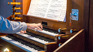 Nahaufnahme eines Organisten, der eine Pfeifenorgel spielt