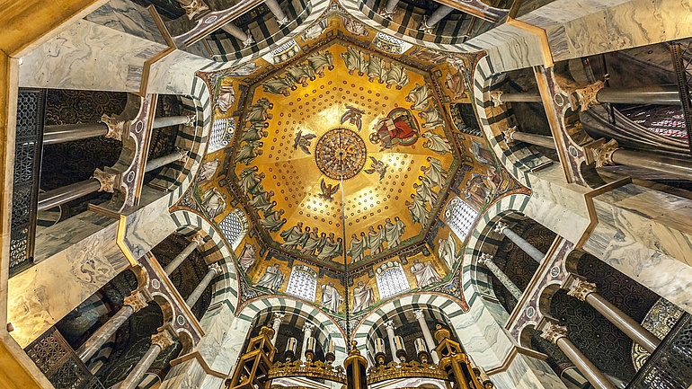 Blick von unten auf die innere Kuppel des Aachener Doms.