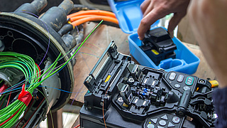 Ein Glasfaser-Kabel und ein technisches Gerät.