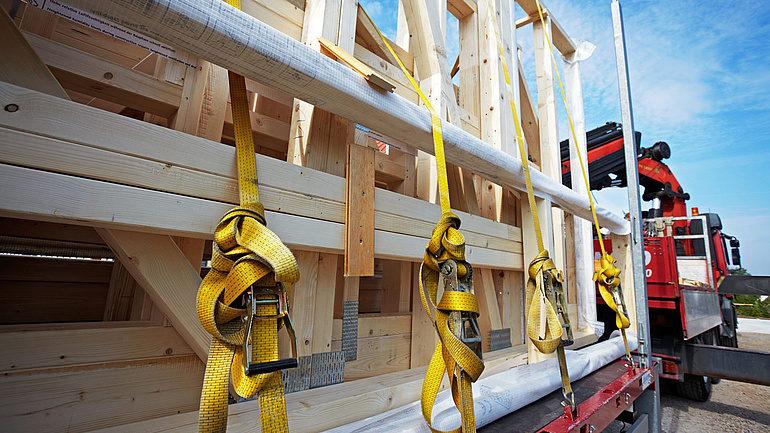 LKW mit Anhänger transportiert ein Holzelement