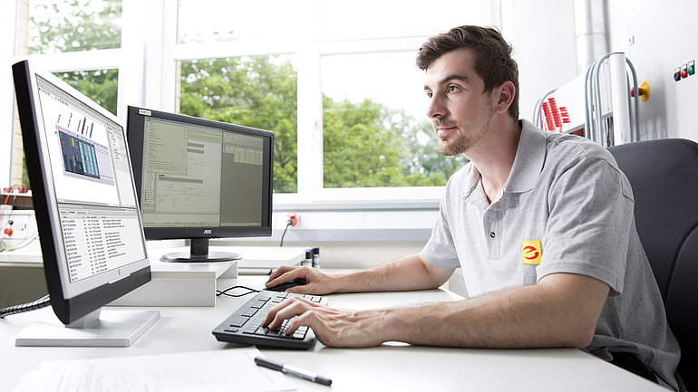 Elektroniker für Automatisierungstechnik sitzt am Computer