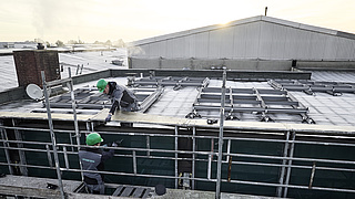 zwei Männer bauen ein Gerüst