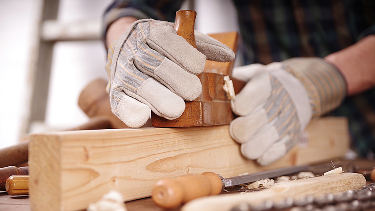 Schreiner bearbeitet ein Stück Holz