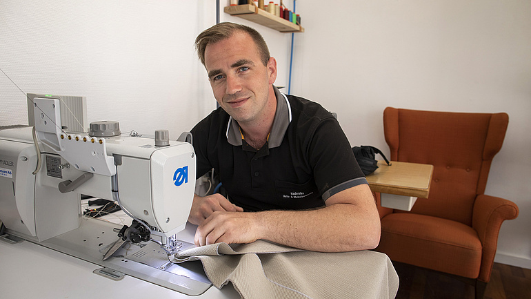 Sattler und Polsterer Jonas Moos arbeitet an einer Nähmaschine.