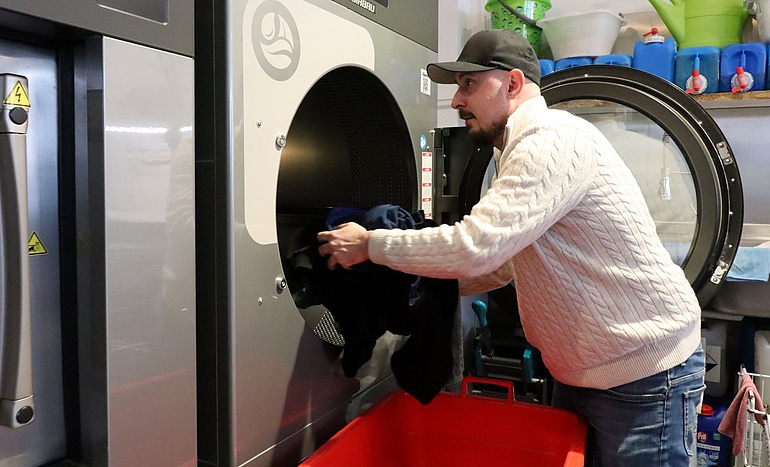 Pawel Banach befüllt eine der riesigen Waschmaschinen.