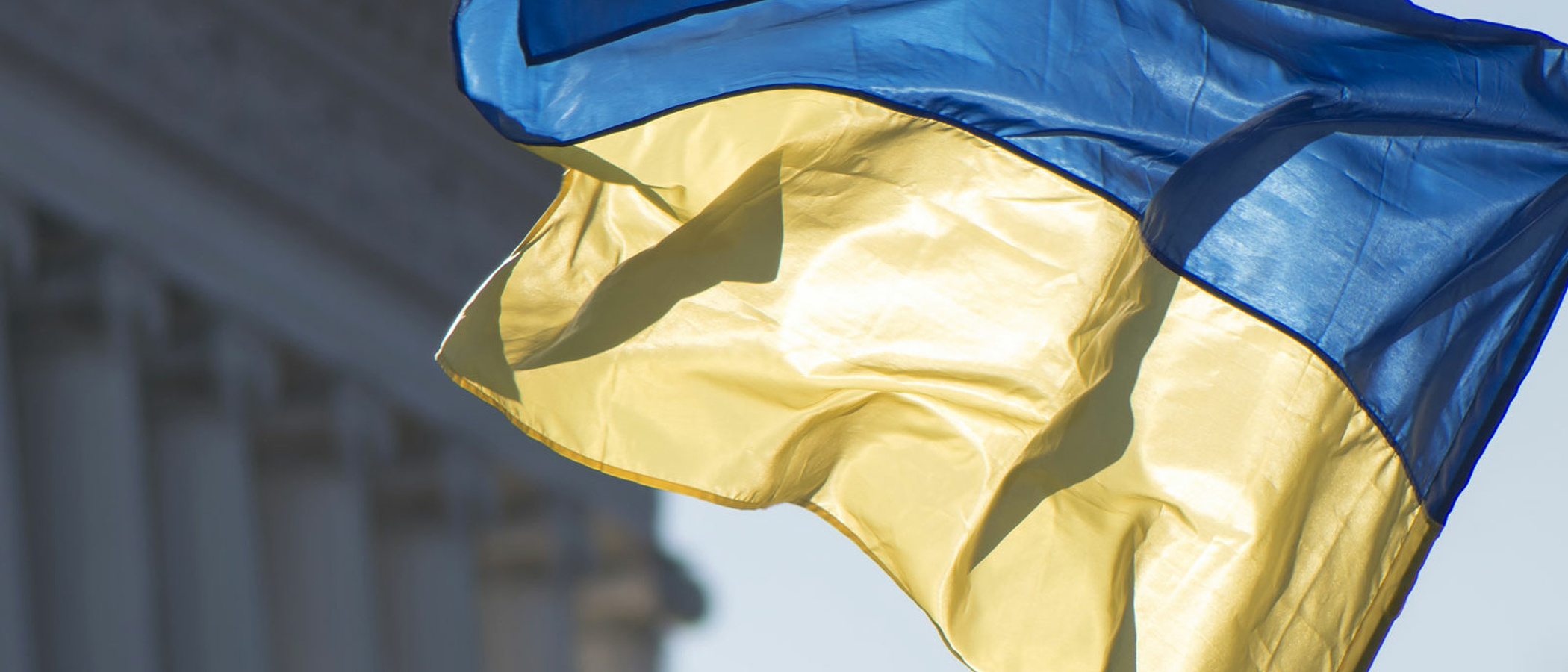 Flagge der Ukraine vor einem historischen Gebäude.