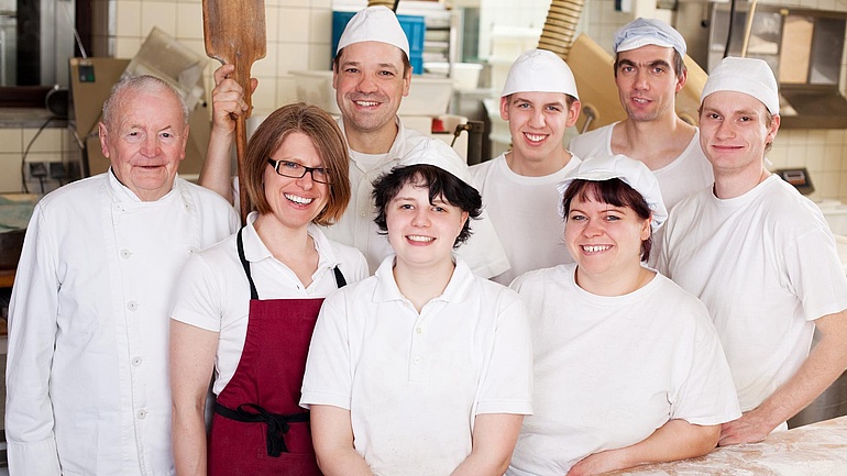 Team einer Backstube präsentiert sich gut gelaunt vor der Kamera.