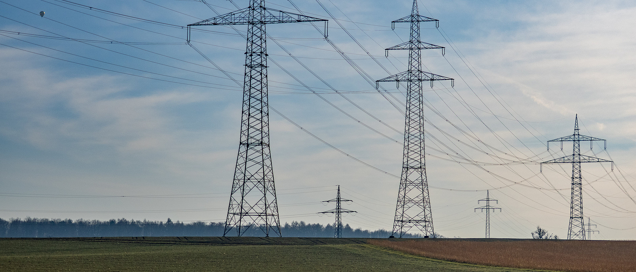 Überlandleitungen auf einem Feld