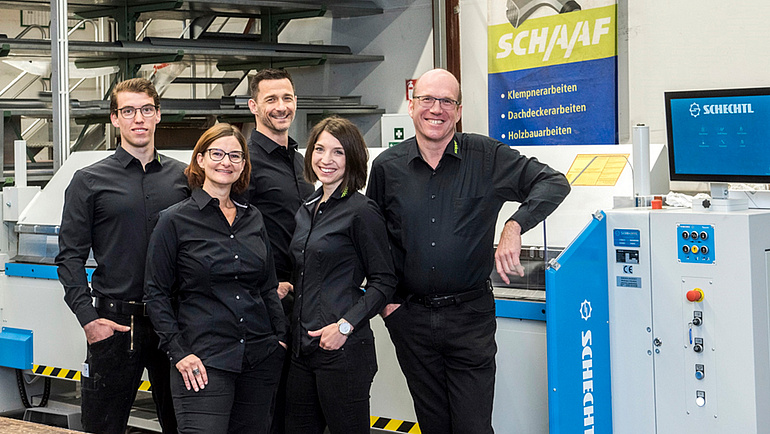 Mehrere Mitarbeiter der Firma Schaaf GmbH stehen in einer Produktionshalle.